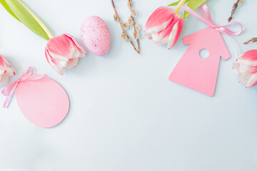 Flat lay easter composition with pink tulips and eggs on color background