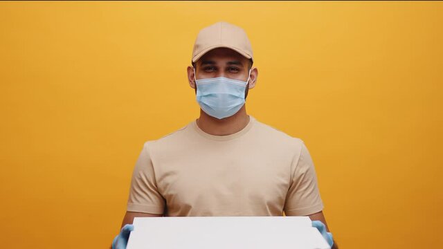 Delivery man smiling while holding pizza boxes. Ordering food during pandemic. High quality 4k footage