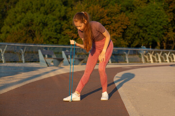 Sporty red head woman doing exercises with an expander