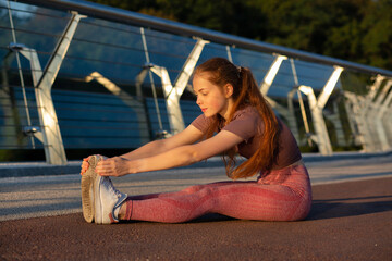 Flexible ginger woman warms up at the bridge