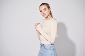 Pretty model in beige blouse and jeans. Glow makeup, healthy skin and so natural. - obrazy, fototapety, plakaty