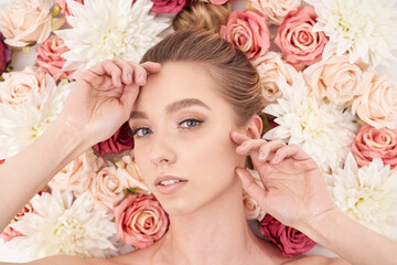 Beautiful white girl with flowers. Stunning blonde girl with big bouquet flowers of roses.  - obrazy, fototapety, plakaty