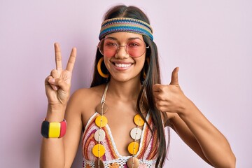 Beautiful hispanic woman wearing bohemian and hippie style doing peace symbol smiling happy and...