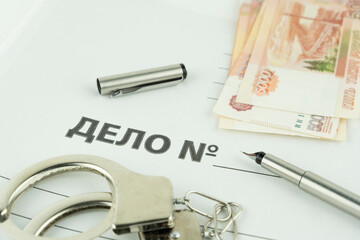 folder and label dealing with handcuffs and money. translation: business