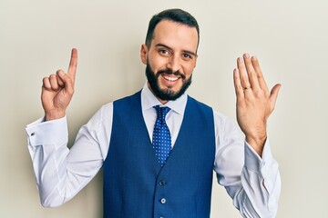 Young man with beard wearing engagement ring surprised with an idea or question pointing finger with happy face, number one