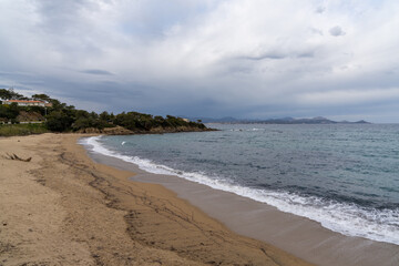 golden sand beach on the French Riviera under an expressive overcast sky