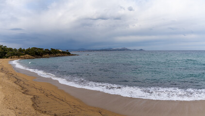 golden sand beach on the French Riviera under an expressive overcast sky