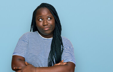 Young black woman with braids wearing casual clothes smiling looking to the side and staring away thinking.