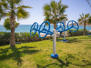 Fitness equipment installed for the public in a picturesque resort area overlooking the beach.