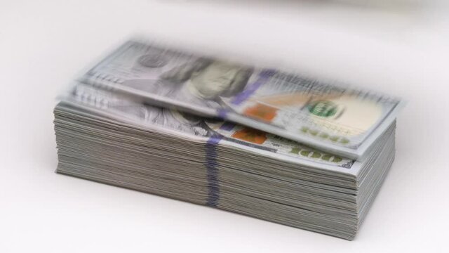 Wind blows or blowing 100 hundred dollars banknotes off the table. Bank financial concept