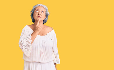 Senior woman with gray hair wearing bohemian style thinking concentrated about doubt with finger on...