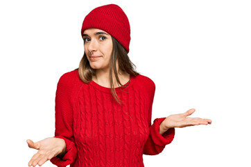 Young hispanic woman wearing casual clothes clueless and confused expression with arms and hands...