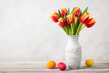 Easter background with fresh tulips and painted eggs