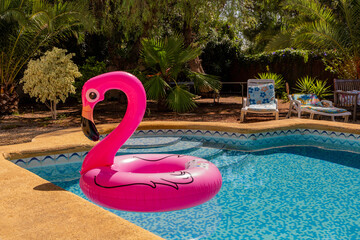 inflated pink flamingo in the pool