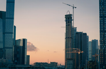 Construction of residential high-rise buildings at sunrise