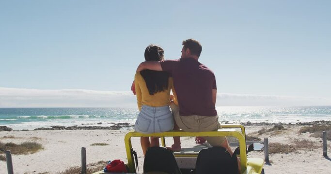 Happy caucasian couple sitting in beach buggy by the sea talking - Powered by Adobe