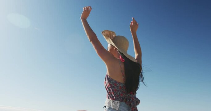 Happy caucasian woman sitting on beach buggy by the sea waving hands
