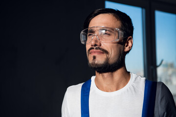 Man in blue overalls, white shirt and goggles