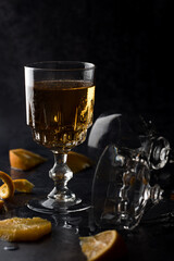 Clear crystal glass filled with golden liquor on dark background.