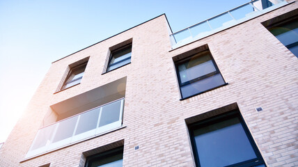 Image of condo on afternoon with sun set. Contemporary white residential building against a blue sky. Ideal for illustration of real estate or investment concepts.