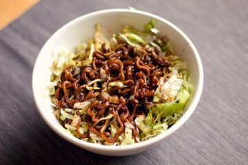 bowl of homemade thai noodles with fresh salad and soy sauce