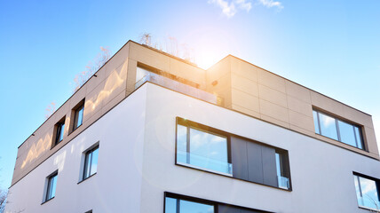 Image of condo on afternoon with sun set. Contemporary white residential building against a blue sky. Ideal for illustration of real estate or investment concepts.