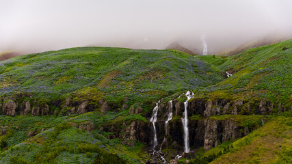 spectacular waterfall on a eastern Icelandic fjord near Seydisfjordur during summer season