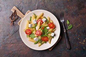 Penne pasta with cherry tomatoes, soft cheese, green beans, spinach and arugula leaves