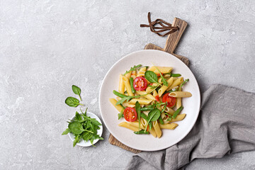 Penne pasta with cherry tomatoes, green beans, spinach and arugula leaves