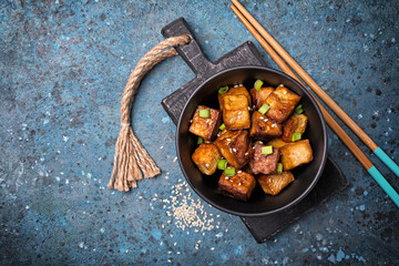 Bowl of fried tofu with sesame seeds and green onion