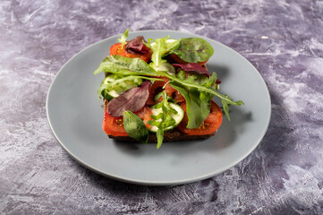 Vegan sandwich with vegetables. A sandwich with vegetables on a plate. Square sandwich on a plate.