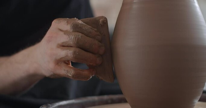 Potter shapes a jug in slow motion on a potter's wheel, video from pottery workshop, potter makes ceramics in slow motion, 4k 60p Prores HQ 10 bit