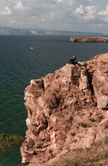 Woman on top of a cliff overlooking Lake