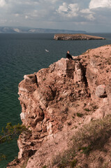 Woman on top of a cliff overlooking Lake