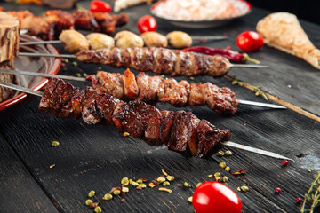 Variety of caucasian shashlyq skewers with different meat on the wooden background
