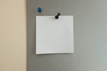 a piece of paper pinned to a gray board. office atmosphere.