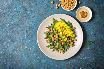 Healthy vegetarian food: cooked chickpeas with fresh arugula and avocado