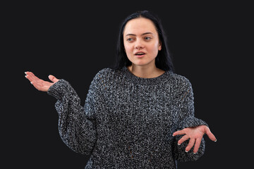 woman with long hair wearing gray sweater on a black background  gesticulating with her hands