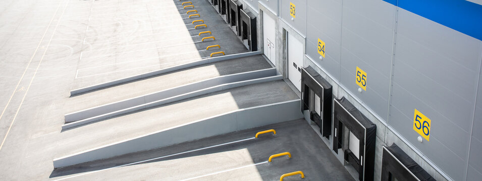 Top view of entrance rampes of a large distribution warehouse with gates for loading goods