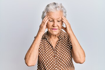 Senior grey-haired woman wearing casual clothes with hand on head for pain in head because stress. suffering migraine.