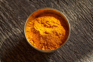 Turmeric powder in a bowl on a table