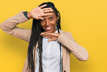 African american woman wearing business jacket smiling cheerful playing peek a boo with hands showing face. surprised and exited
