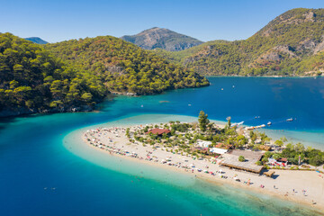 Naklejka premium aerial view to white sand beach between emerald lagoon and sea with copy space