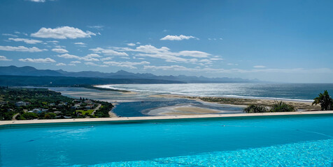 Panoramic view over Plettenberg Bay and Keurboomsrivier, South Africa with pool in foreground.