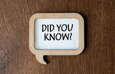 A wooden plaque with the inscription DID YOU KNOW lies on the table. View from above. Flat lay....