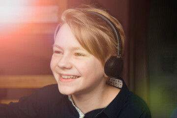 Naklejka premium Distance Learning, Home-based Learning. A boy in headphones does his homework