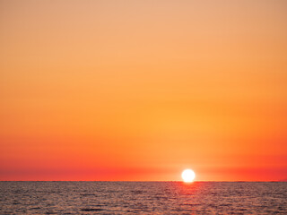 sunset at sea with sun on horizon with copy space