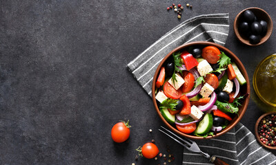 Classic Greek salad with feta and olives on a concrete background.