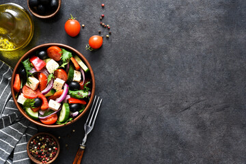 Classic Greek salad with feta and olives on a concrete background.
