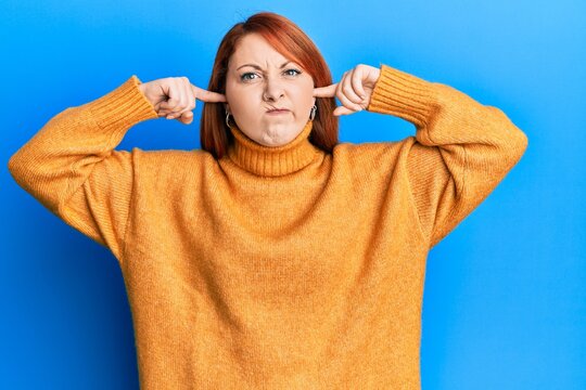 Beautiful redhead woman putting fingers on ears ignoring noise skeptic and nervous, frowning upset because of problem. negative person.